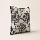 Black and cream Woodland Cushion with tree print and black piping, angled studio view