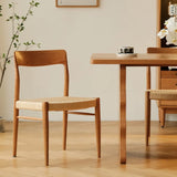 A Qeinn Ratten Naas dining chair crafted from smooth natural wood with a rattan-woven seat